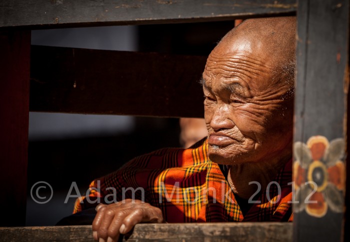 A Buddhist Monk watches a festival in Bumthang. Bhutan Photo tour with Adam monk